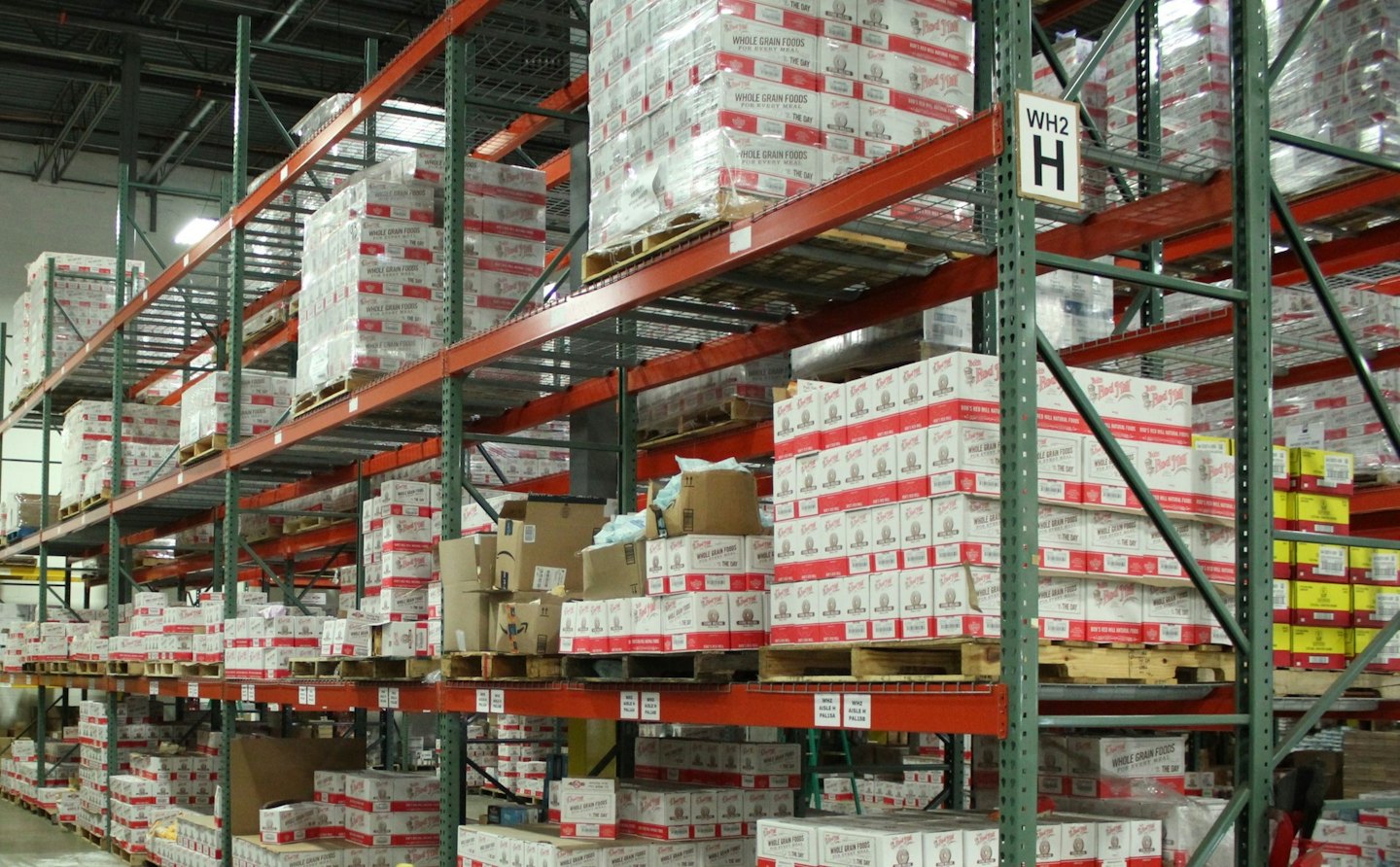 Rows of tall metal shelving units filled with boxes in a warehouse.